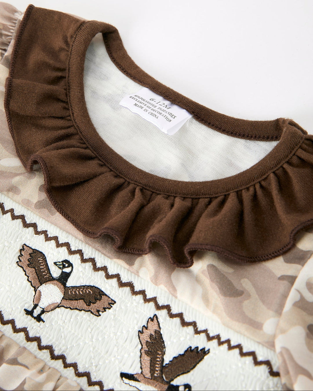 Brown ruffled collar on a white background with embroidered design