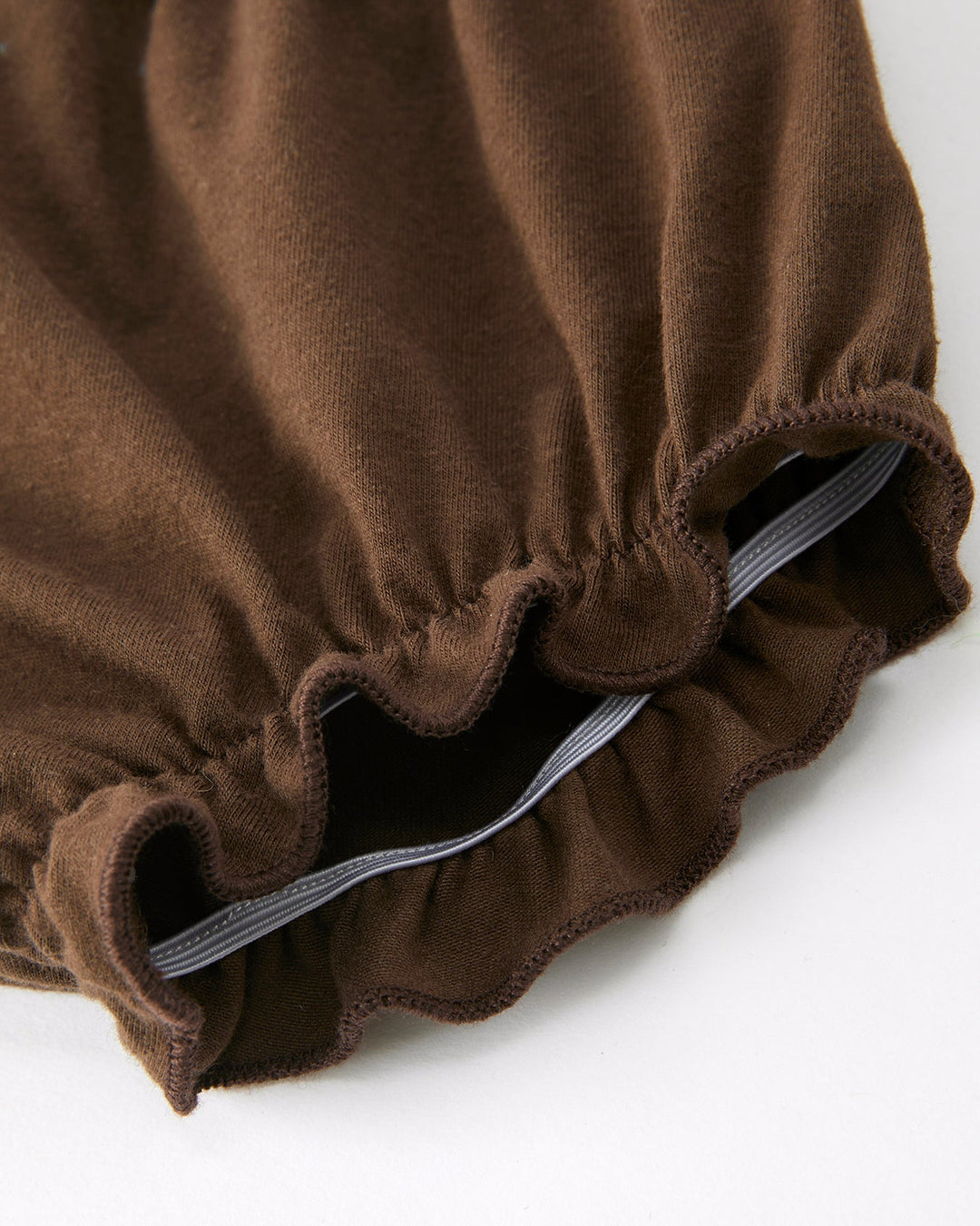 Brown fabric with ruffled edges on a white background