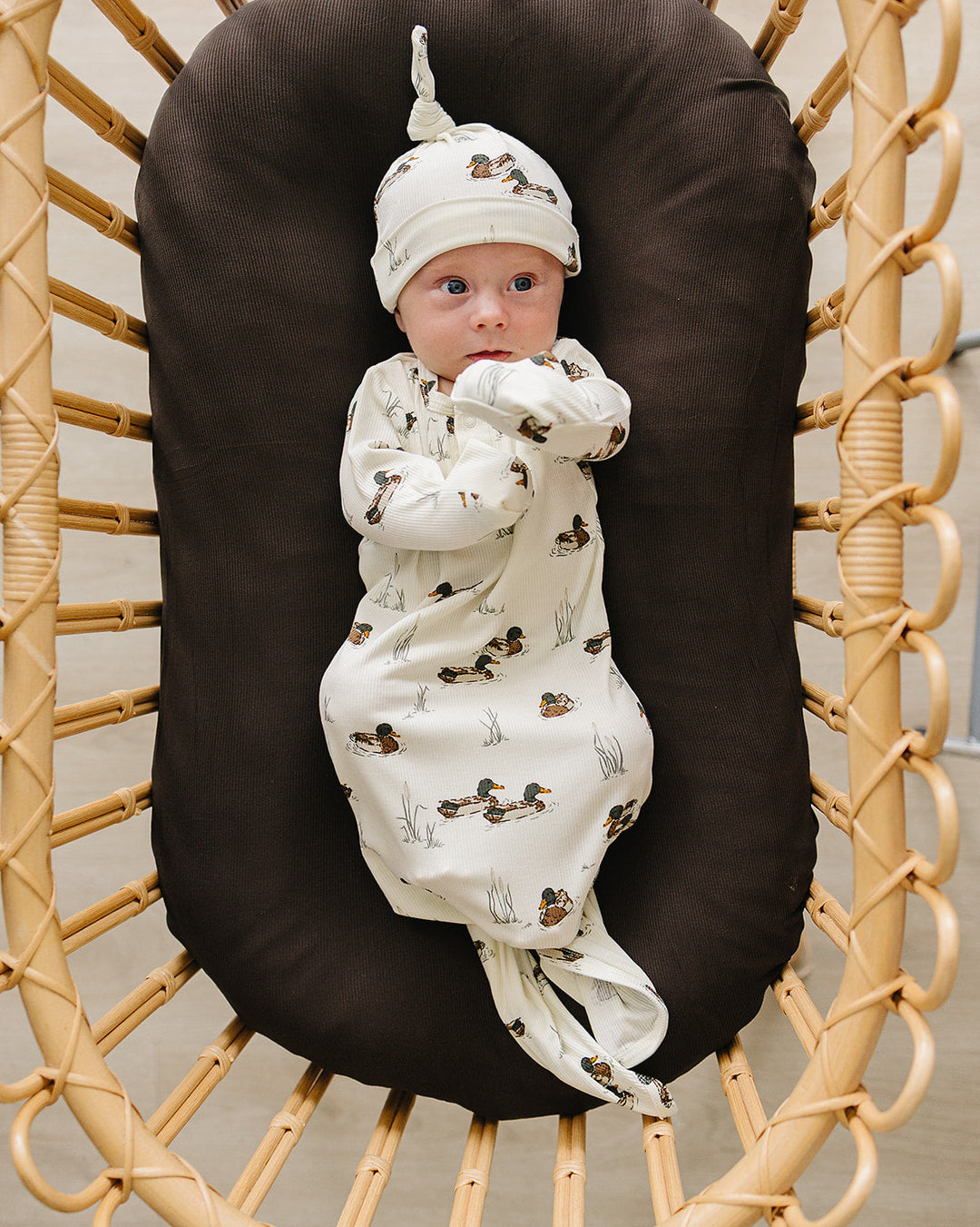 Newborn duck-print knot gown with tied waist, long sleeves, cream allover animal print