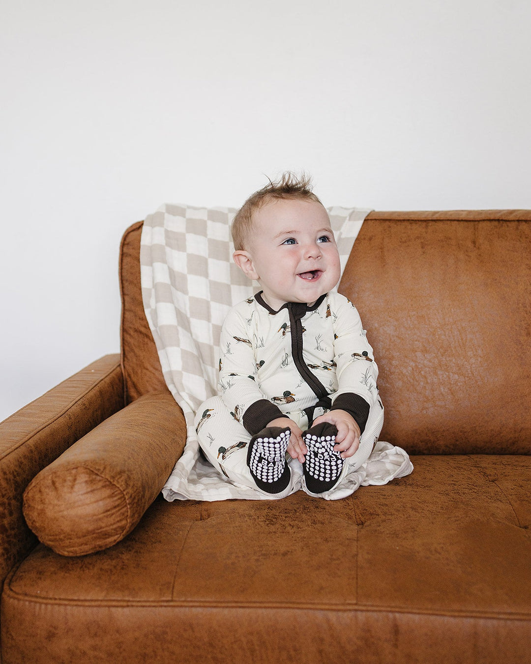 Infant duck-print zip sleeper with black ribbed cuffs, front zip opening