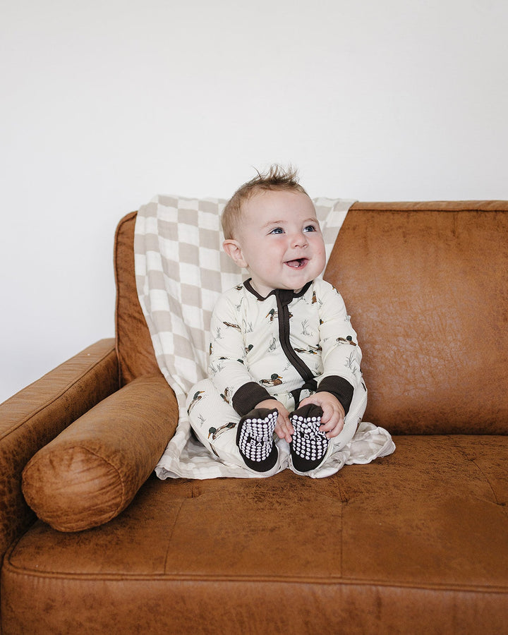 Infant duck-print zip sleeper with black ribbed cuffs, front zip opening