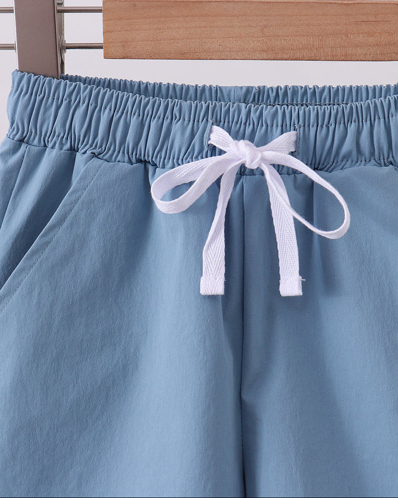 Dusty blue performance shorts with elastic waist and white drawstring tie