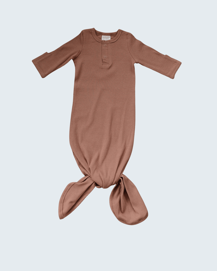 Dusty rose baby gown with a knot at the bottom on a light gray background