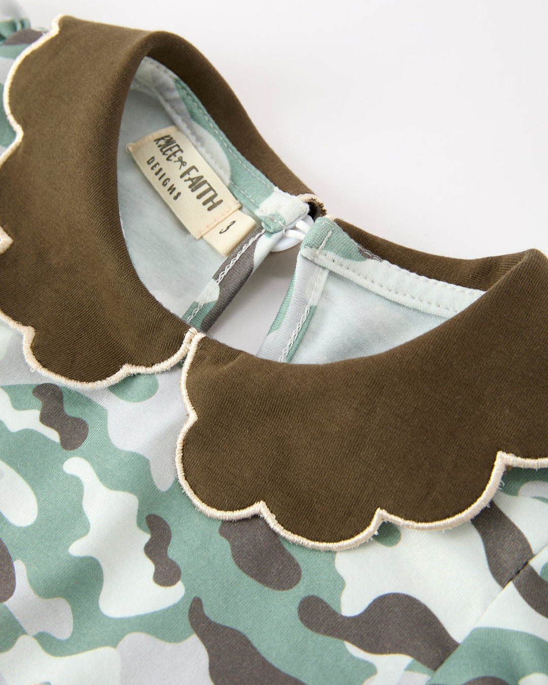 Camo dress neckline closeup with brown scalloped Peter Pan collar trim