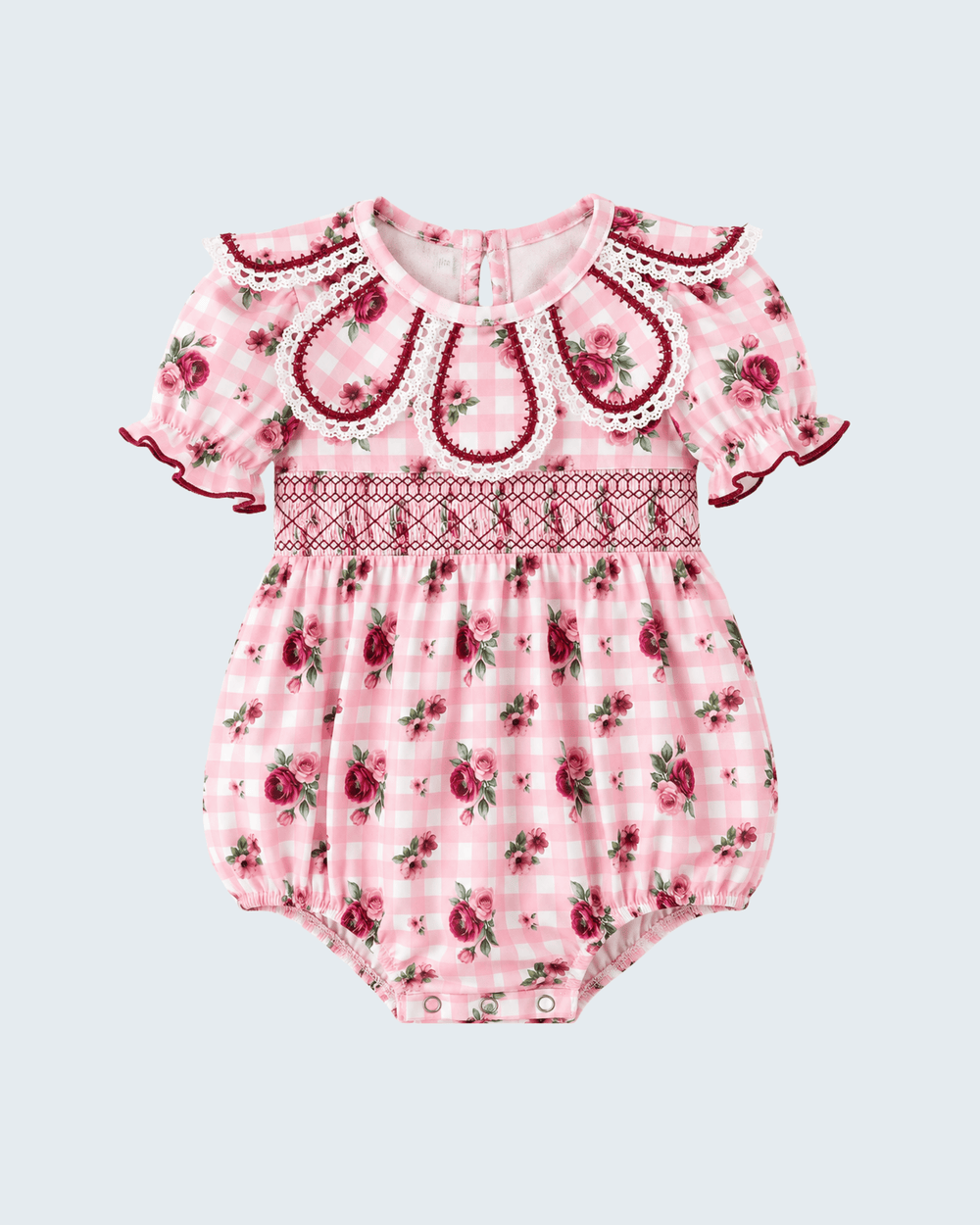 Pink floral romper with embroidered yoke, scalloped neckline, ruffle sleeves, and snaps