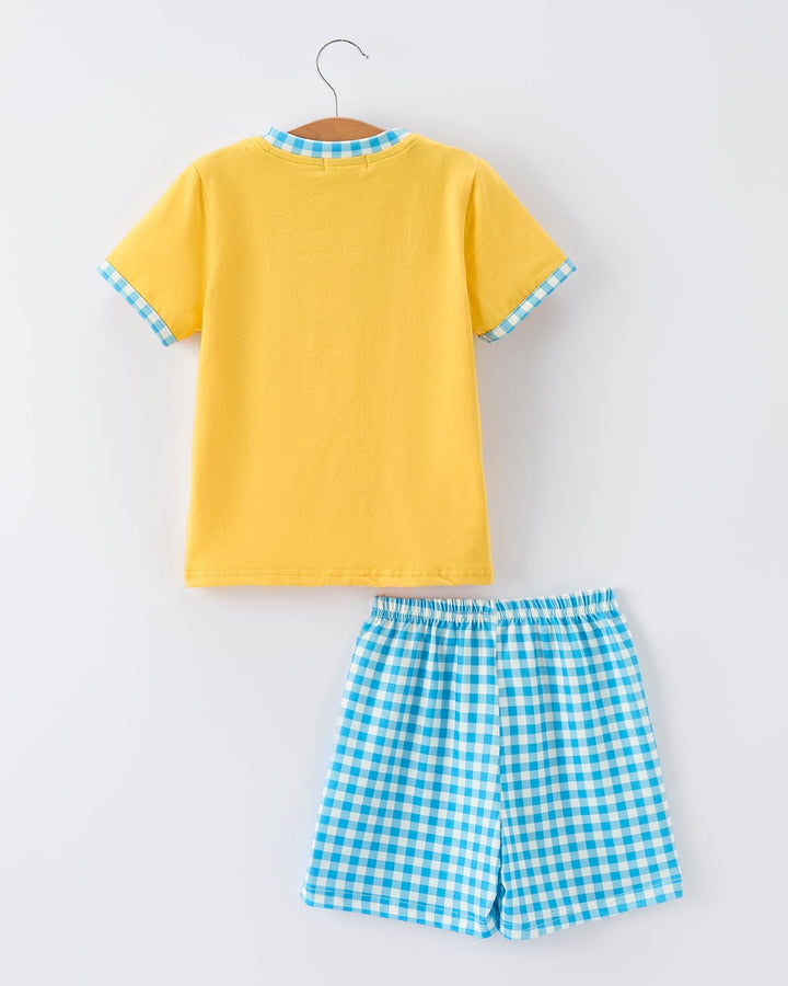 Yellow shirt and blue checkered shorts set on a white background