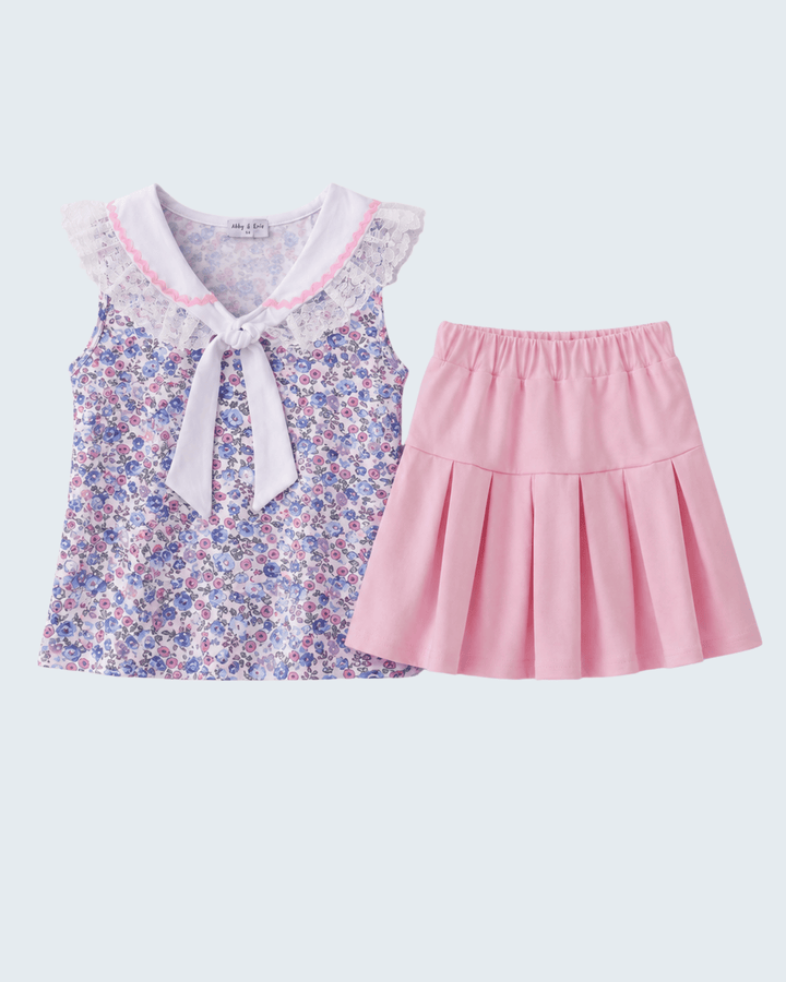 Floral top with a bow and pink skirt on a light gray background