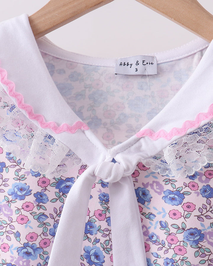 Floral dress with pink trim on a hanger, featuring the brand &