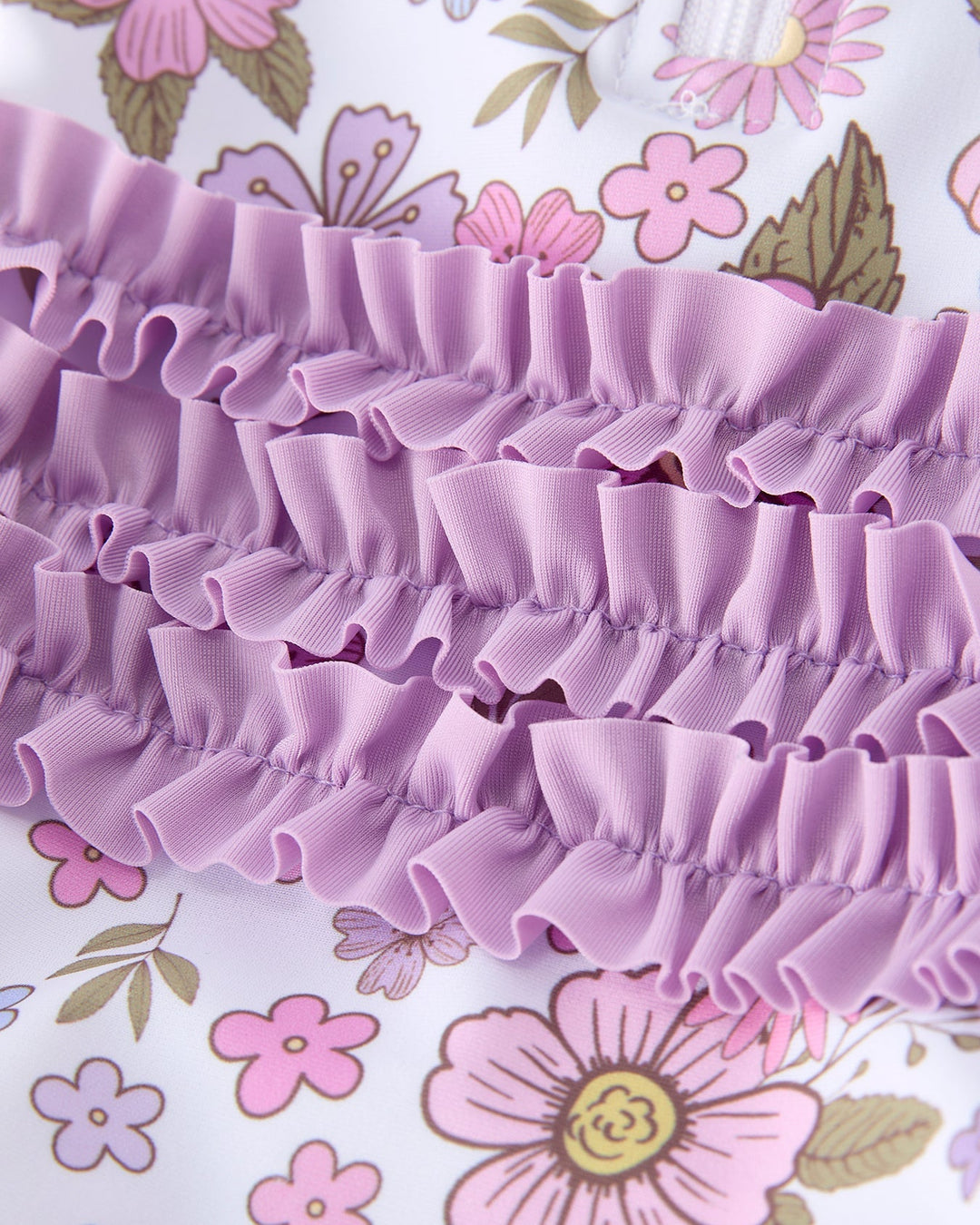 Close-up of a purple ruffled fabric with a floral background