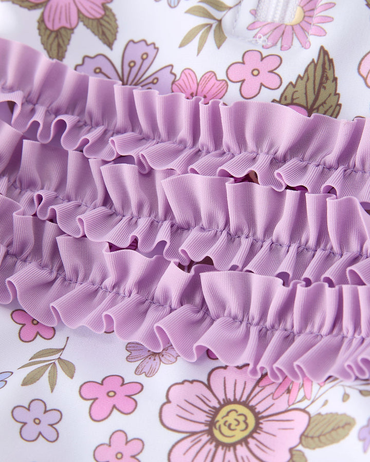 Close-up of a purple ruffled fabric with a floral background