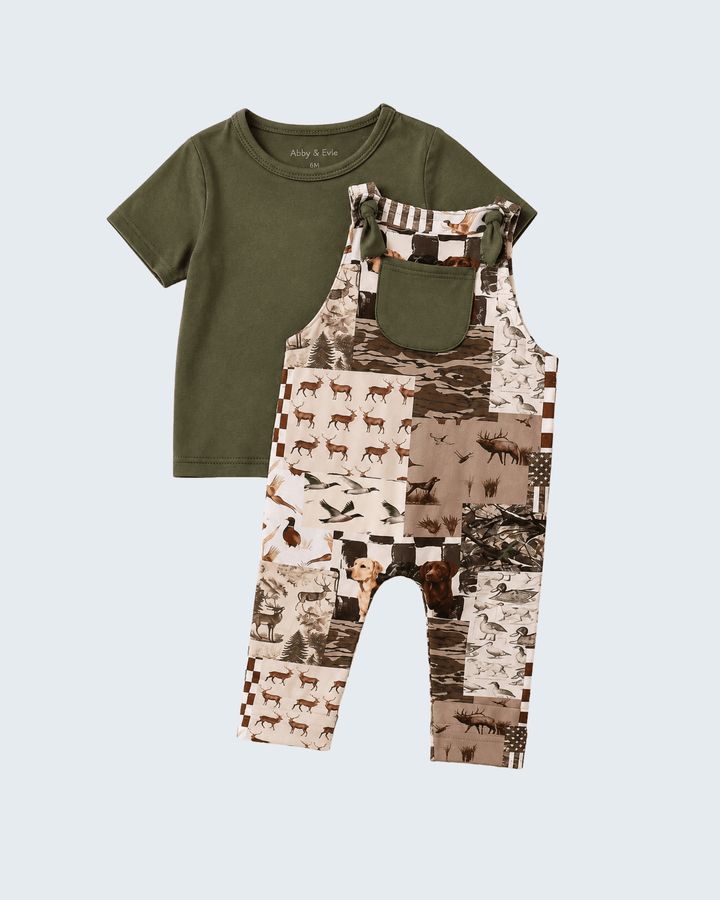 Baby &amp; Ico toddler two-piece outfit set featuring an olive green short-sleeve t-shirt and matching bib overalls with a brown and beige woodland animal collage print, displayed on a light gray background.