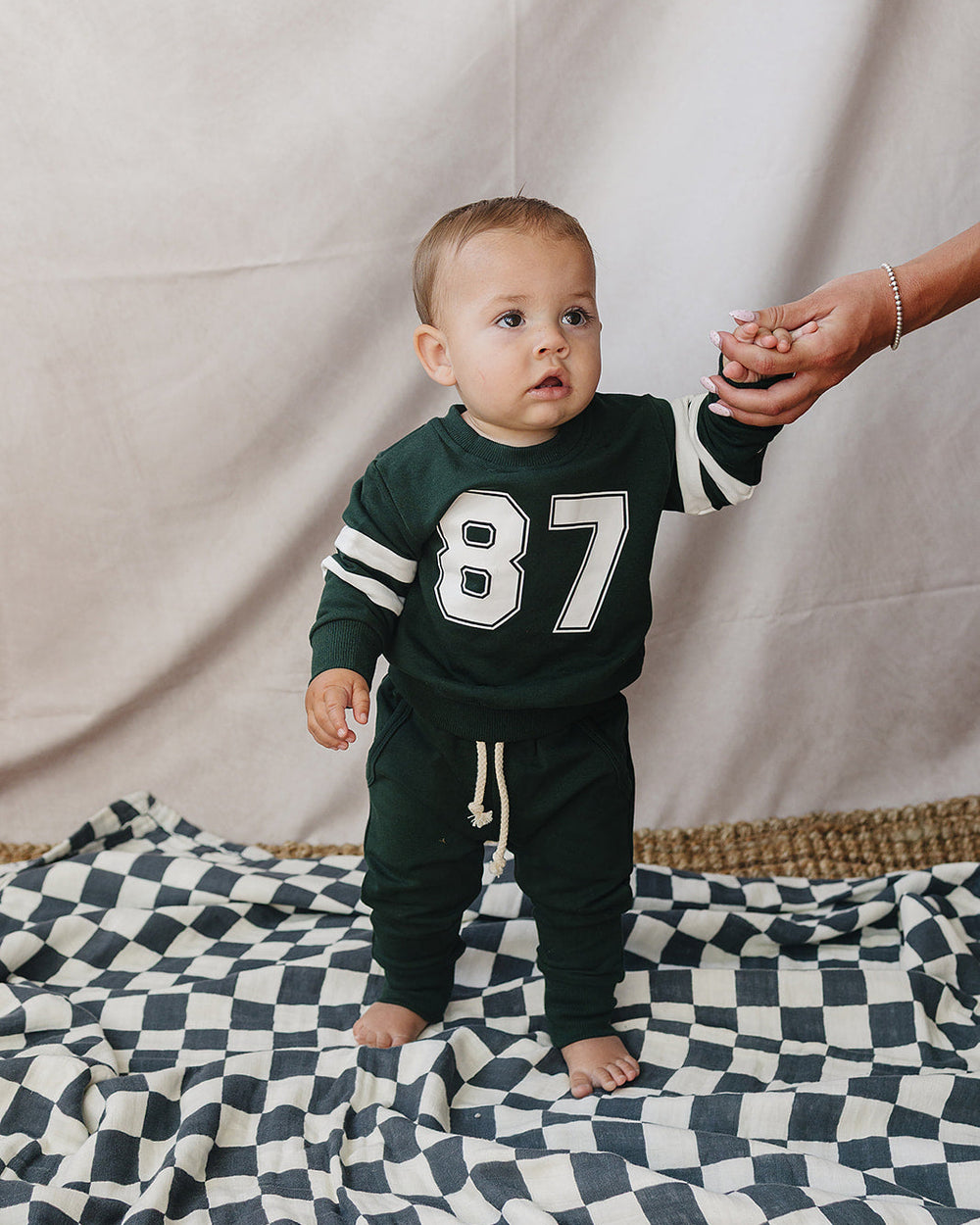 Dark green baby set with '87' sweatshirt and joggers, striped cuffs, white drawstring