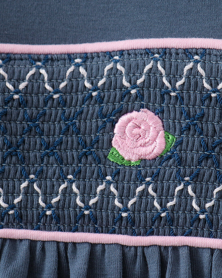 Smocked dark blue romper panel with pink rose embroidery and pink trim stripe
