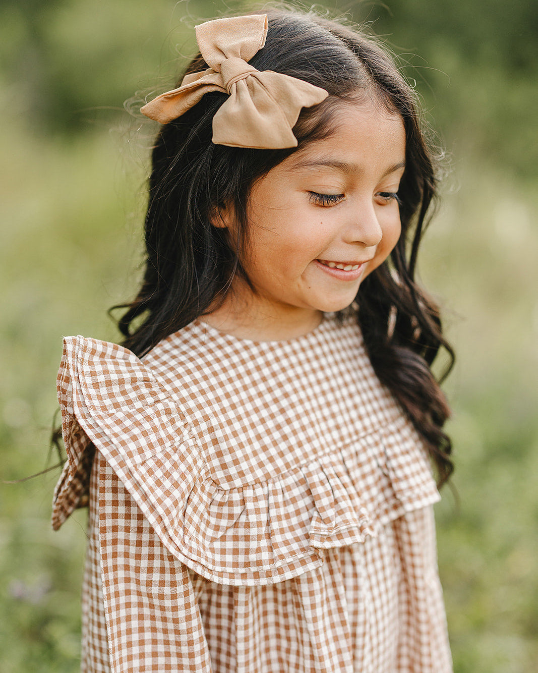 Tan and brown gingham dress with tiered neckline ruffles and shoulder detail