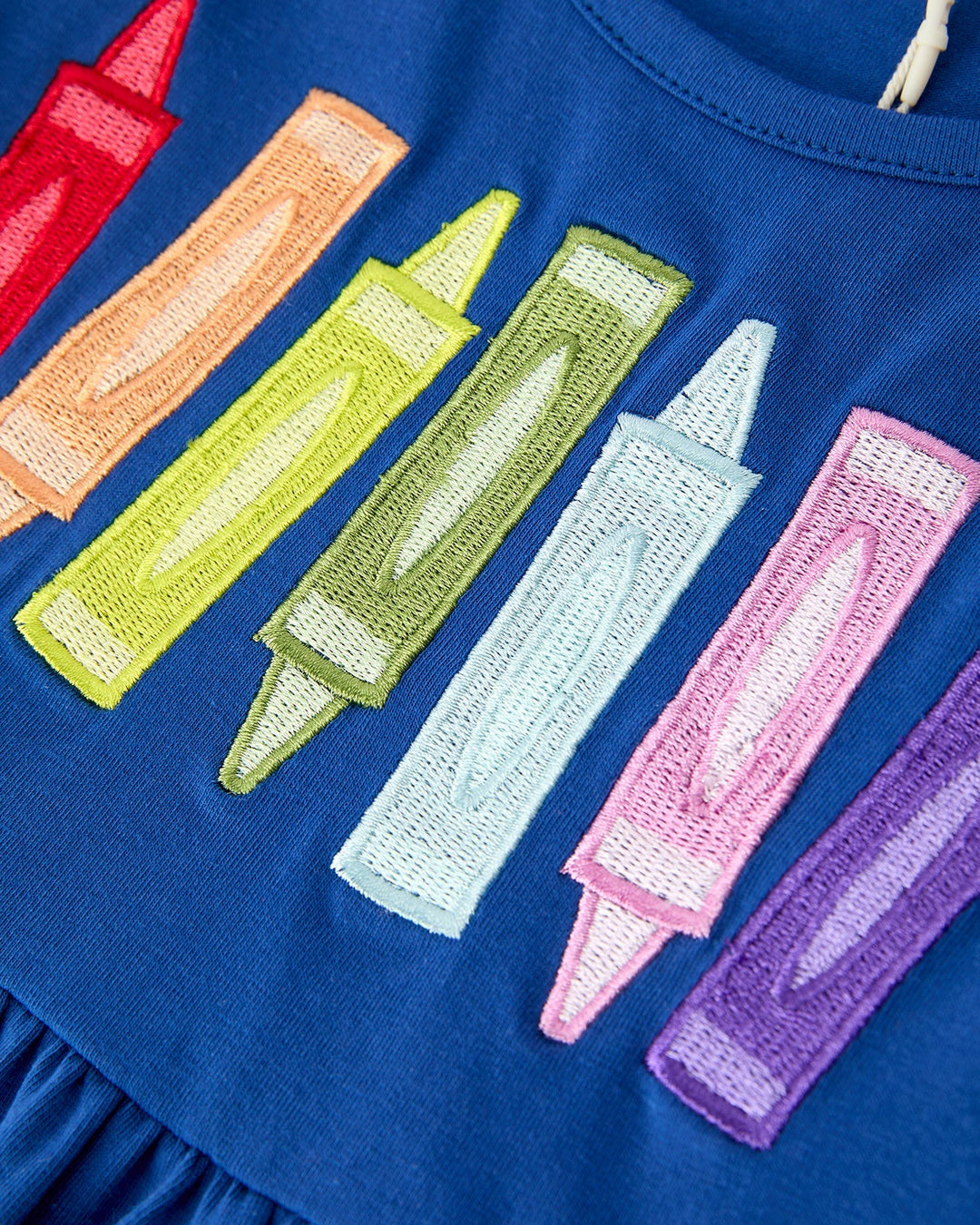 Blue dress with colorful crayon designs on a blue background