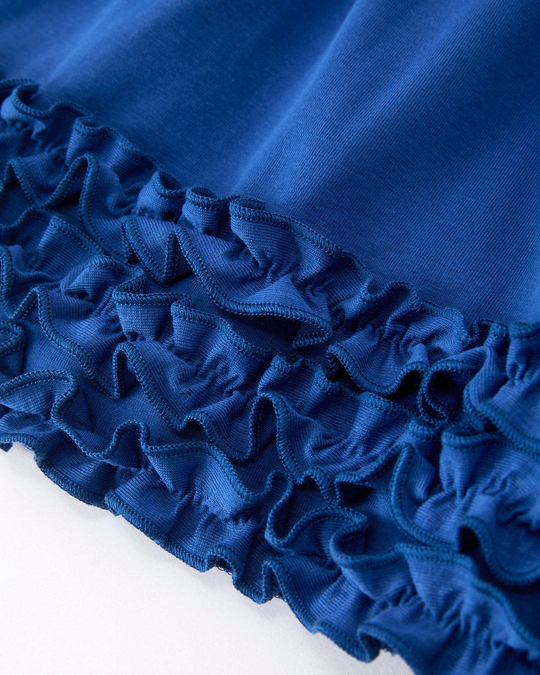 Close-up of blue fabric with ruffled edge on a white background