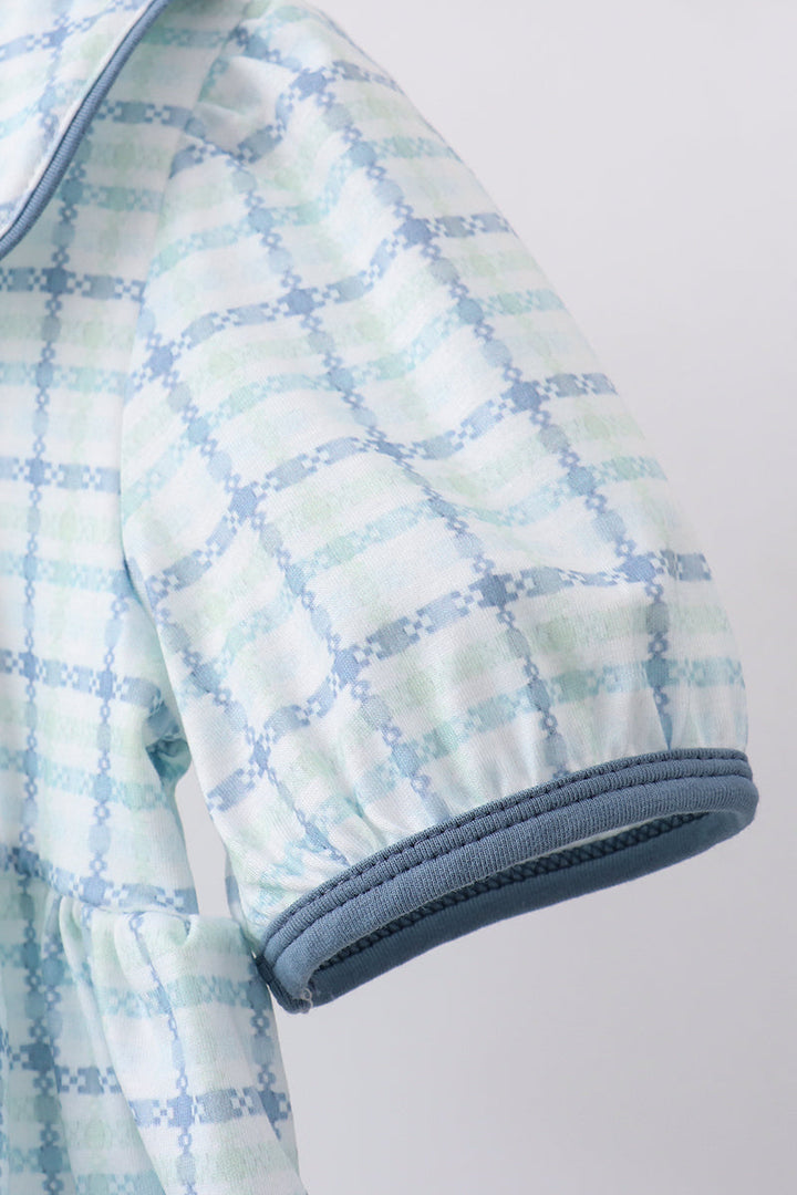 Plaid patterned fabric with blue and white colors on a light gray background