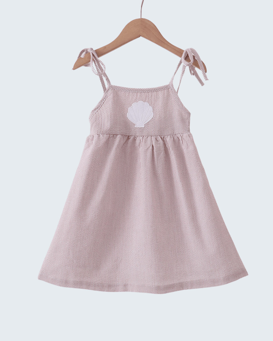 Beige checkered dress with a white flower design on a hanger against a light gray background