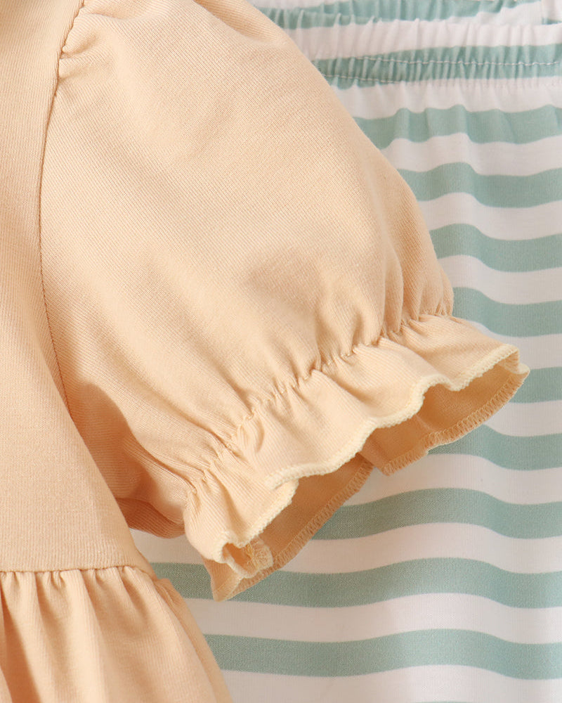 Close-up of beige puff sleeve and ruffled cuff with mint striped pant leg