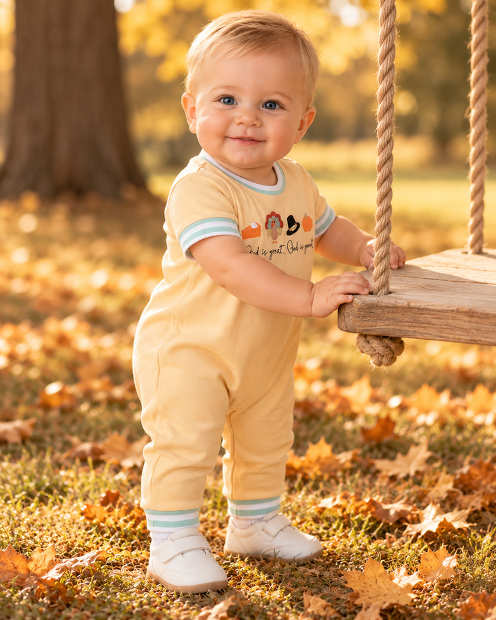 Infant wearing cream romper with embroidered Thanksgiving text, teal striped cuffs and collar