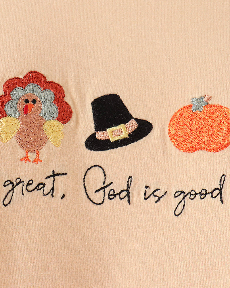 Beige romper close-up with colorful bird, hat, pumpkin embroidery and &