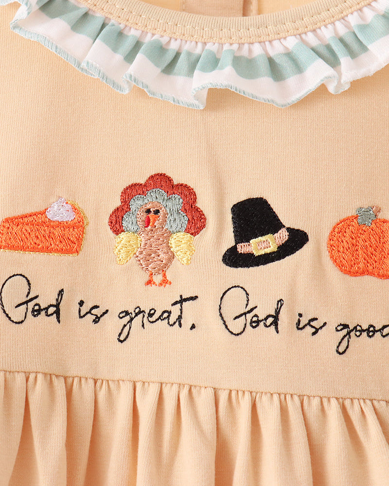Beige dress neckline with scalloped ruffle trim and colorful embroidery text