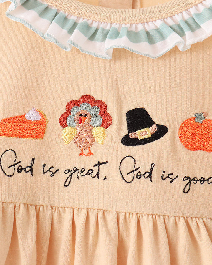 Beige dress neckline with scalloped ruffle trim and colorful embroidery text