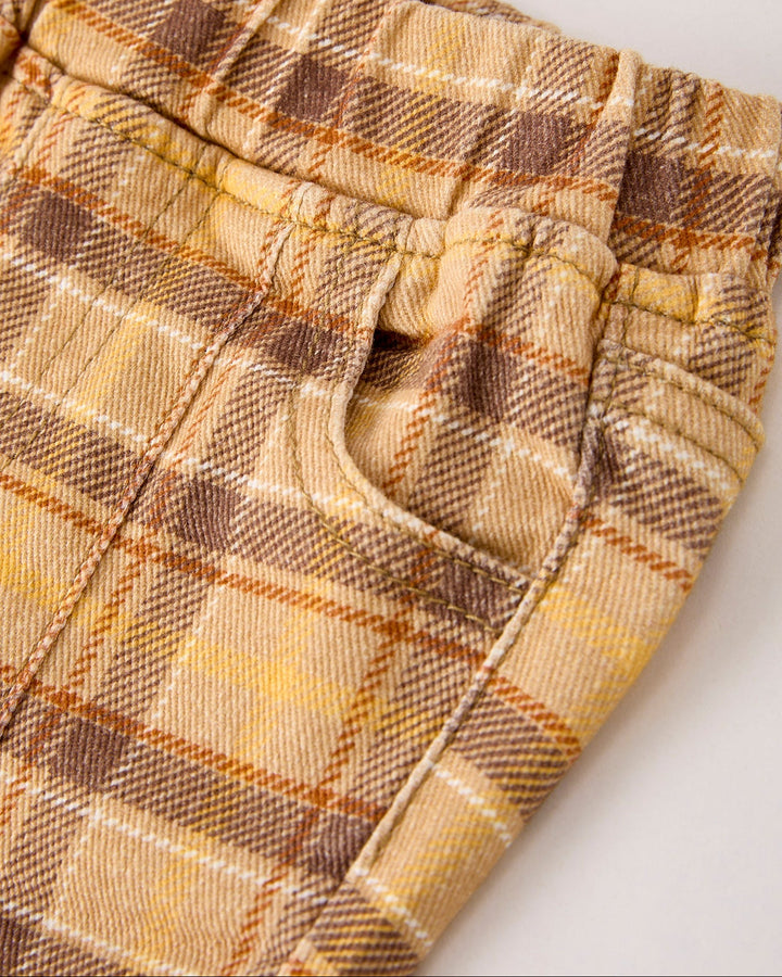 Close-up of plaid girls jeans: elastic waist and button front in yellow-brown check