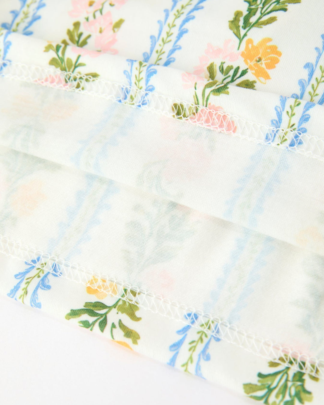 Floral striped baby girl dress fabric with ruffled trim and stitched edge