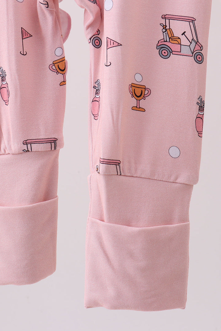 Pink pajama set with golf-themed prints on a light gray background