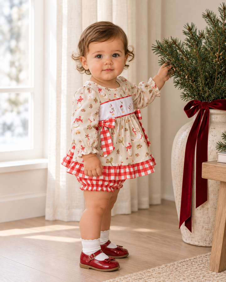 Toddler wearing cream ruffle bloomer set with red animal print and gingham ruffle trim