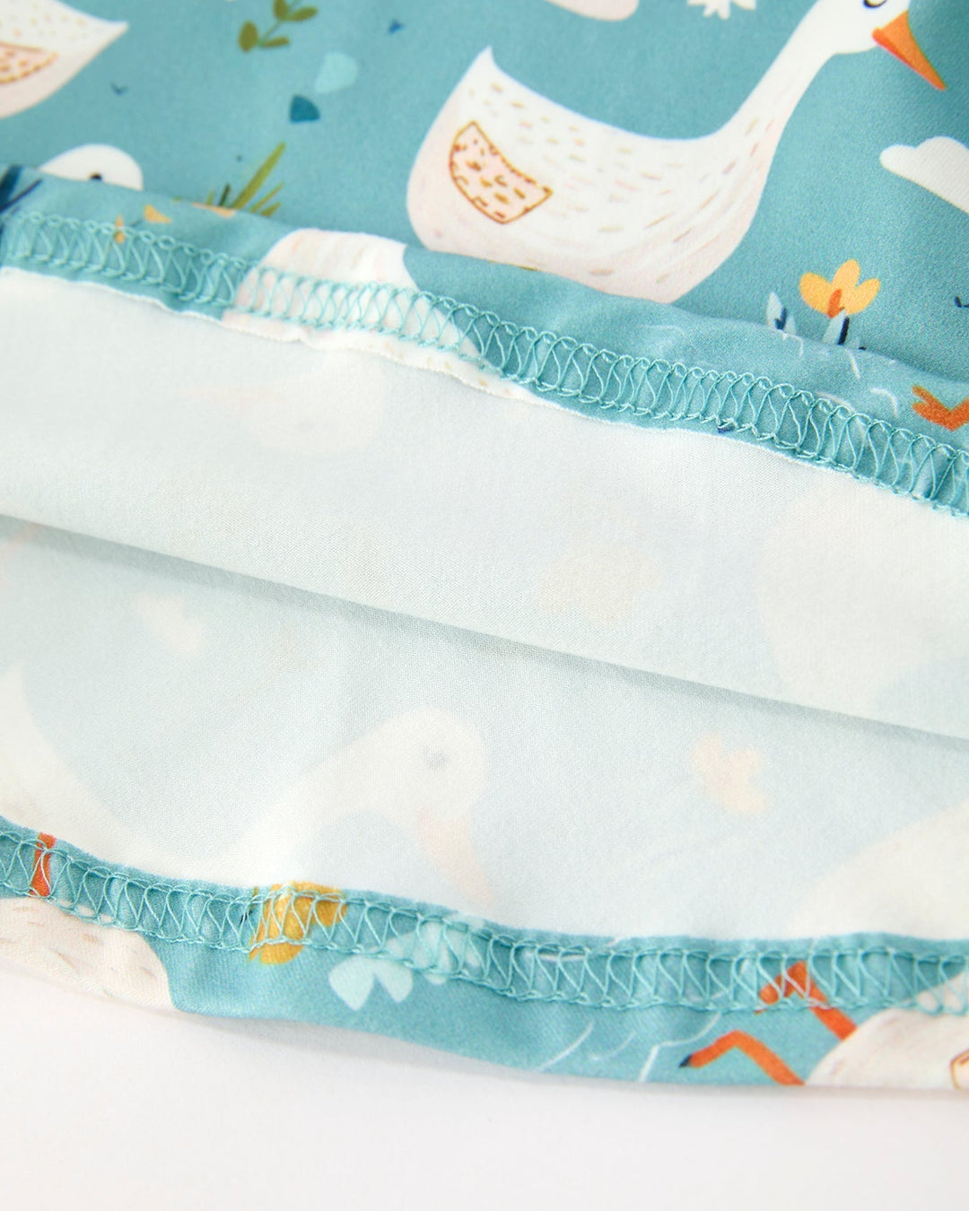 Close-up of fabric with cartoon goose design on a blue background