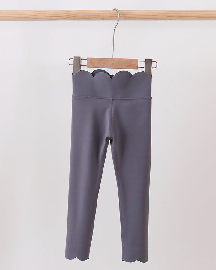 Gray leggings hanging on a wooden hanger against a white background