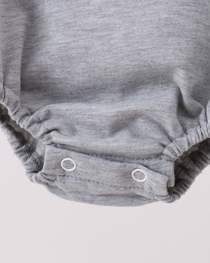 Gray baby romper with button closures on a light gray background