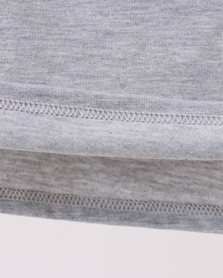 Close-up of a gray fabric with a brown circular patch on a white background