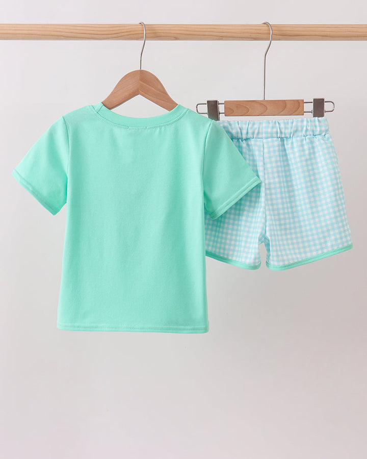 Mint green T-shirt and light blue check shorts set on wooden hangers