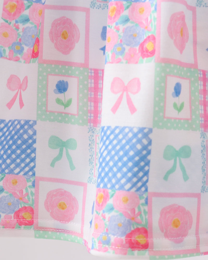Patterned fabric with flowers, bows, and polka dots on a white background