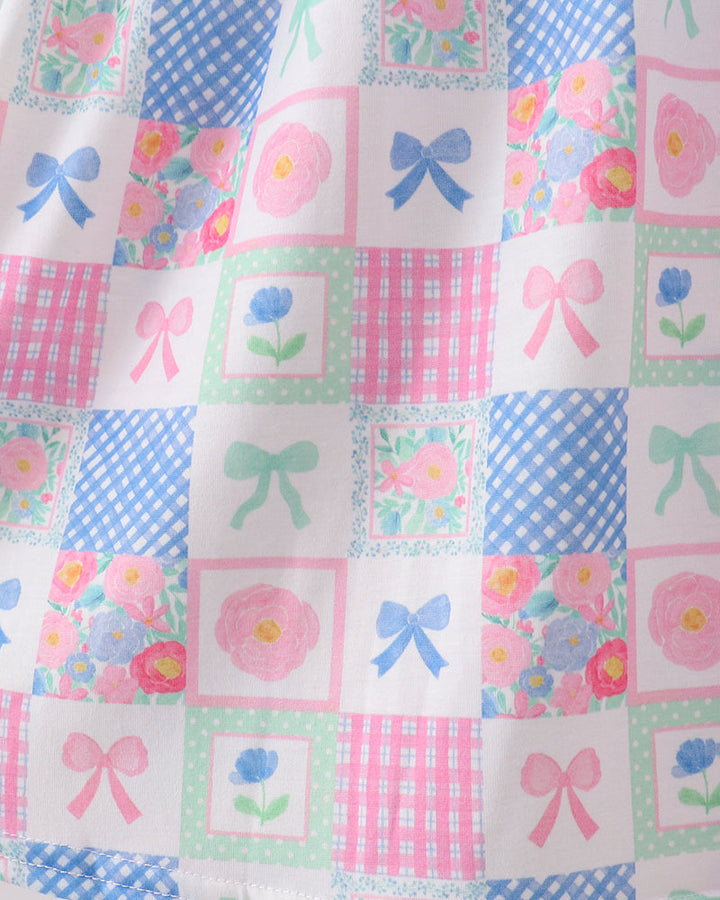 Patchwork fabric with floral and bow patterns on a white background