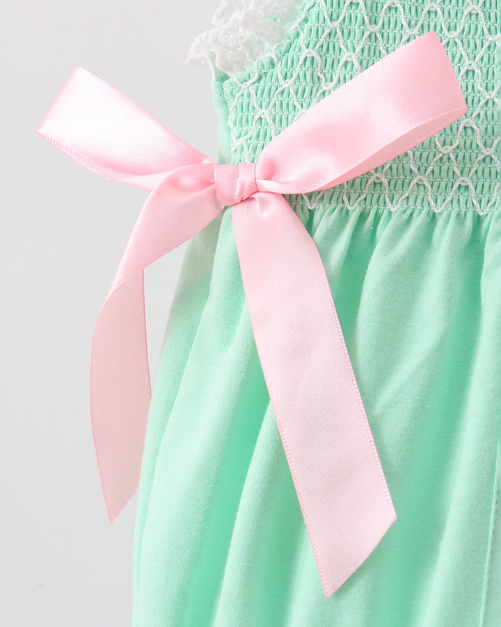 Green romper with a pink ribbon on a light gray background
