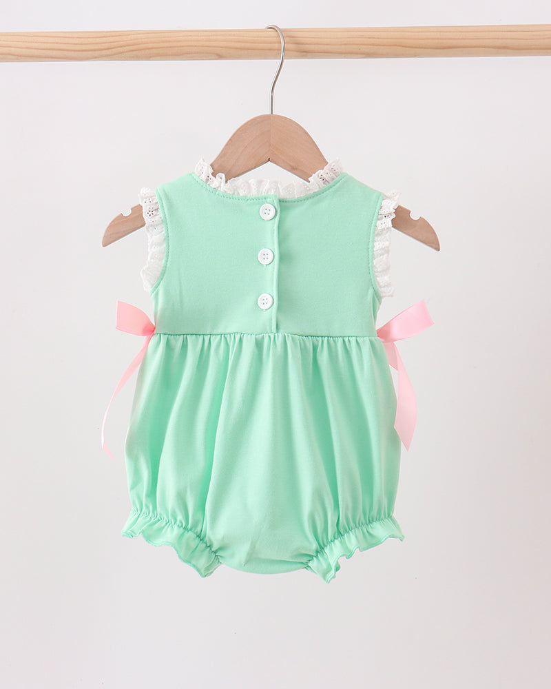 Mint green baby romper with pink bows on a wooden hanger against a white background