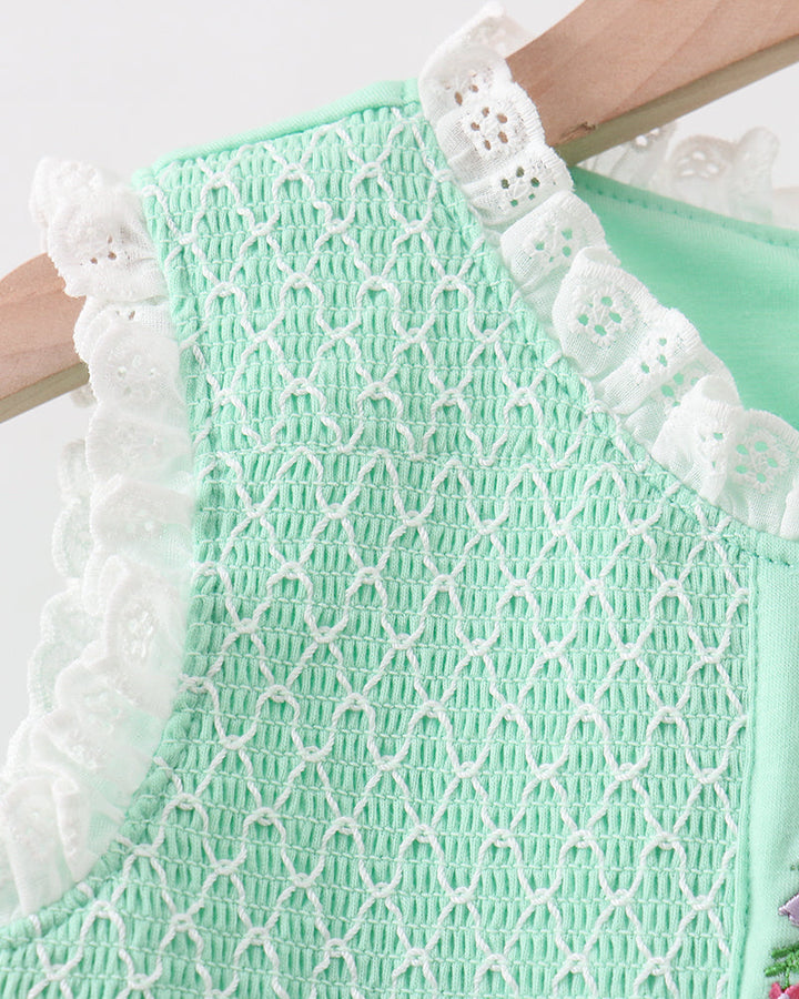 Light green lace dress with white trim on a plain background