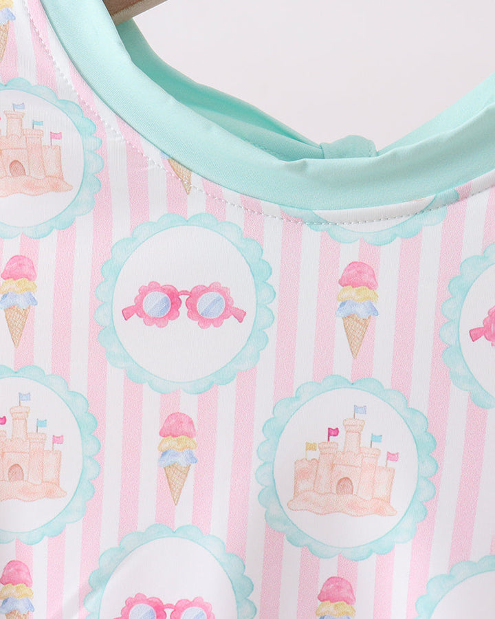 Rashguard with castle and ice cream cone patterns on a pink background.