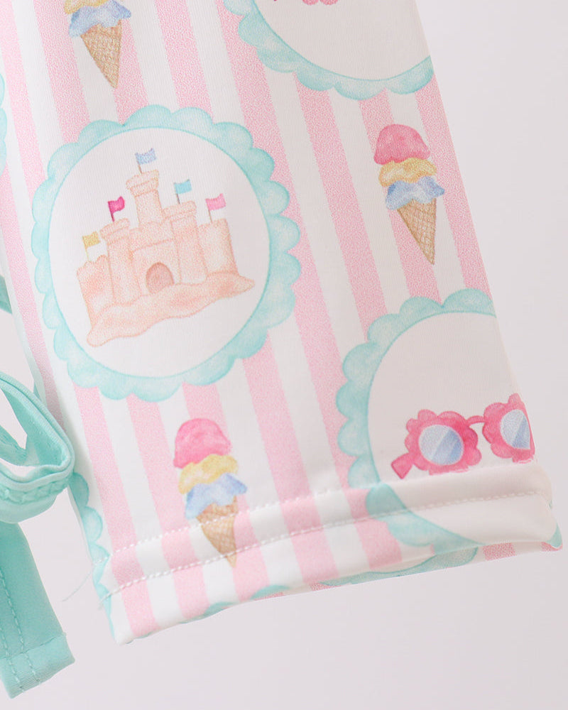Rashguard with ice cream cone, castle, and sunglasses pattern on a white background