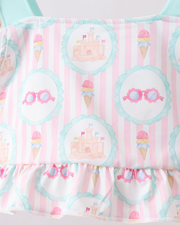 Swimsuit with ice cream and castle pattern on a pink and white striped background