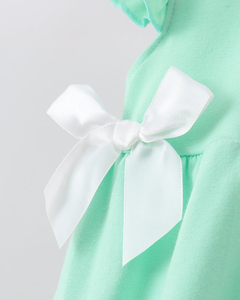 Close-up of a mint green garment with a large white satin bow detail on the front.