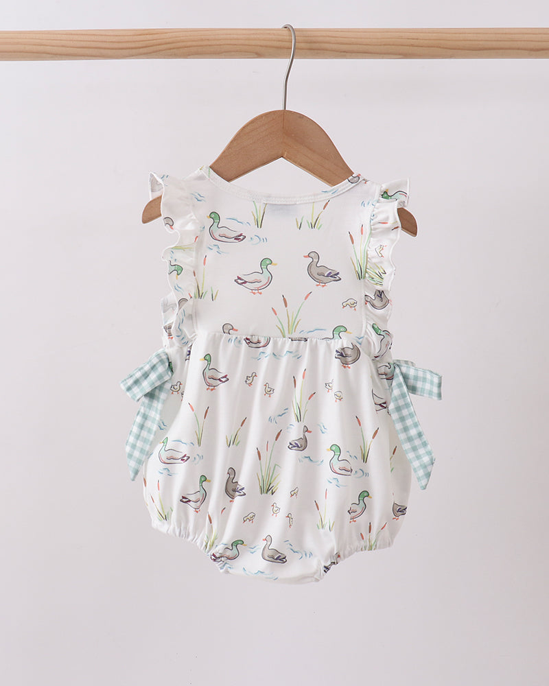 Baby romper with duck pattern on a hanger against a white background