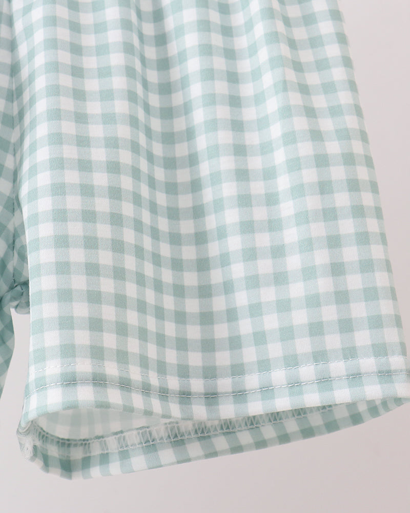 Green and white checkered fabric on a light gray background