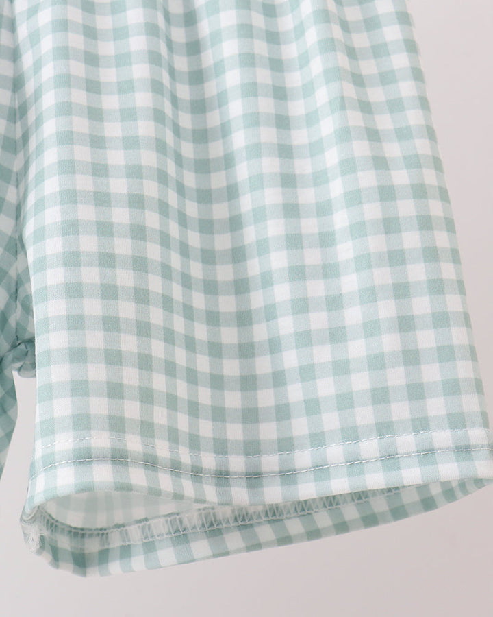 Green and white checkered fabric on a light gray background