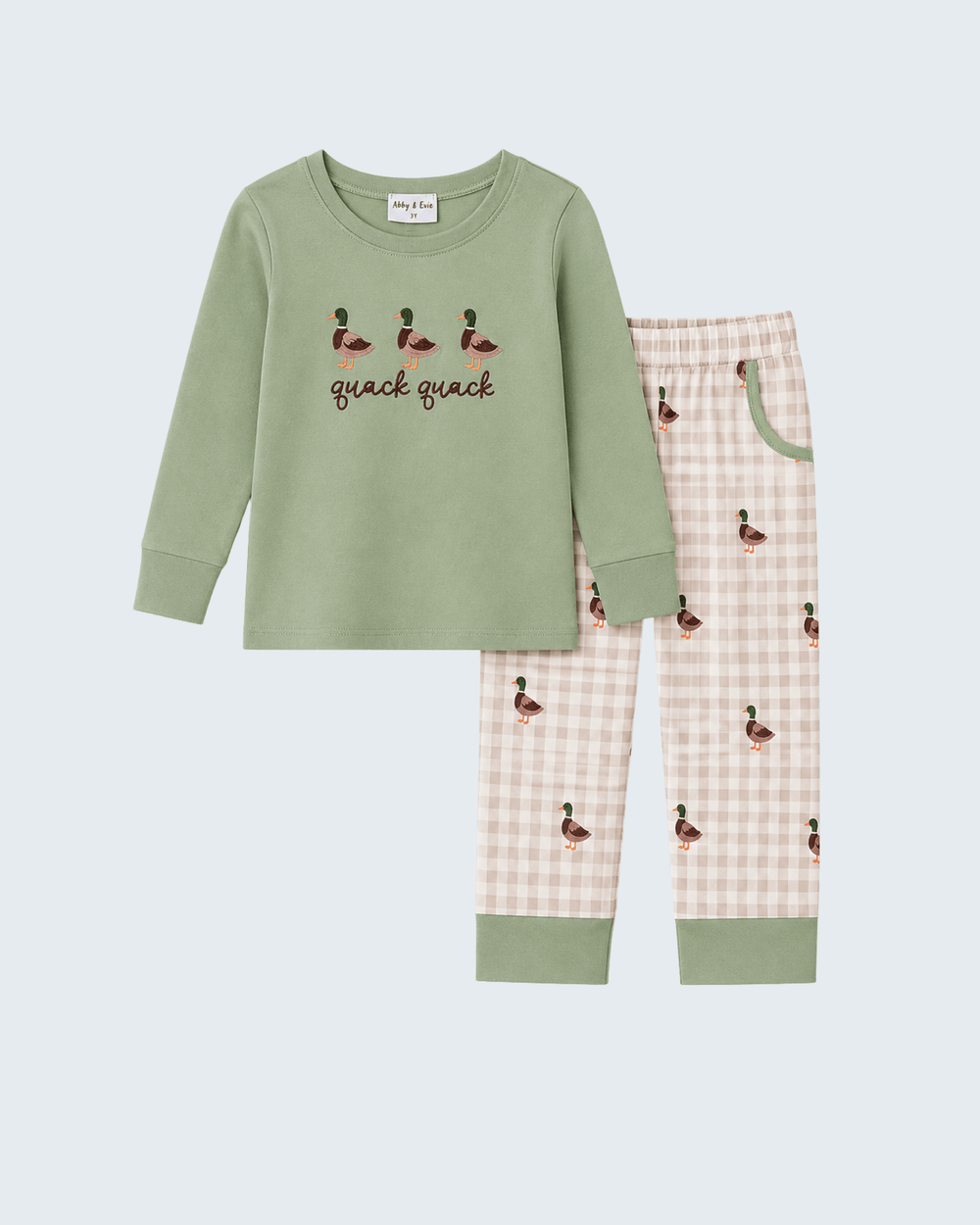 A two-piece children's pajama set featuring a sage green long-sleeve top with duck illustrations and the text 'quack quack' on the chest, paired with pink and white gingham pants decorated with small duck prints and sage green cuffs.