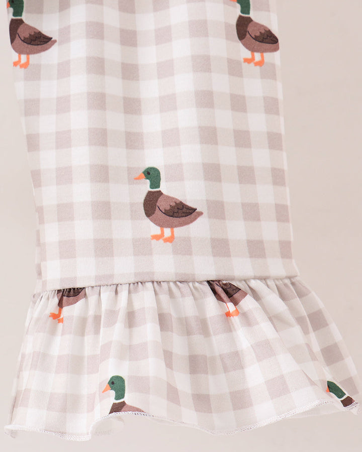 A close-up of a fabric, featuring a beige and white gingham check pattern with printed mallard ducks in brown, green, and orange.